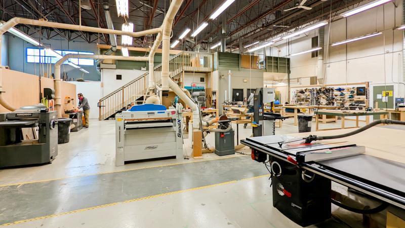 Image of a large communal woodshop with a planer, jointer, sander, sawstop tablesaw, bandsaw, sanders, dust collection, and mitersaws