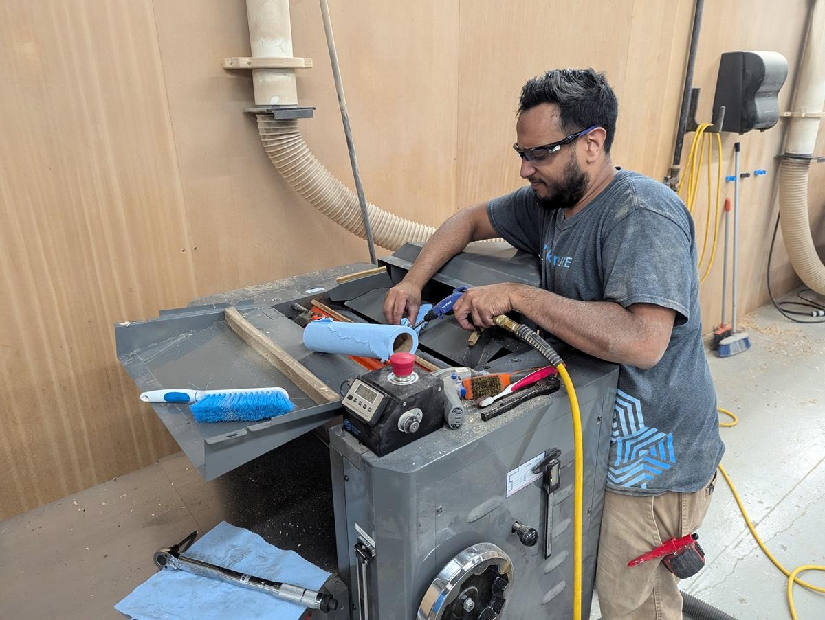 Image of a man doing maintenance on an industrial planer