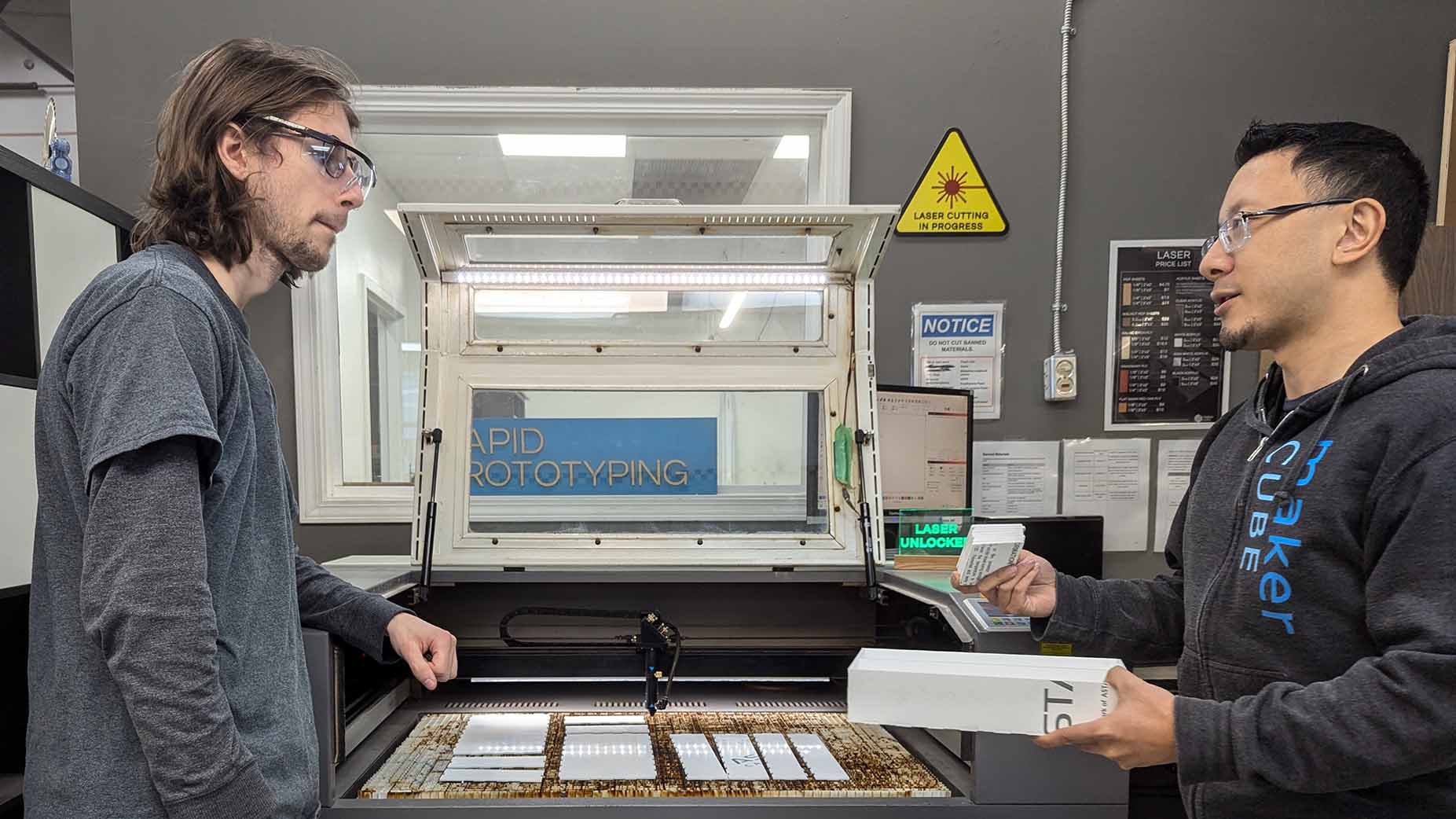 Maker Cube Langley Staff helping a member learn how to use the laser cutter during a laser cutting class